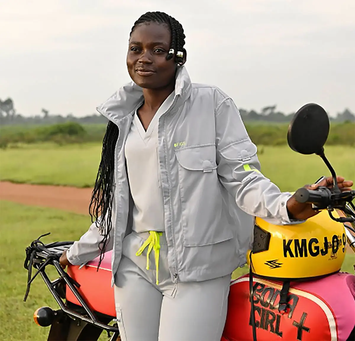 A proud Boda Gilr standing by her bike